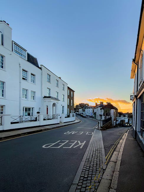 There is no image of flowers or floral arrangements in the provided photograph. Instead, the image shows a quiet, ascending street in Harrow on the Hill during sunset, with white and brown residential